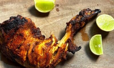 Single tandoori chicken leg with lime wedges