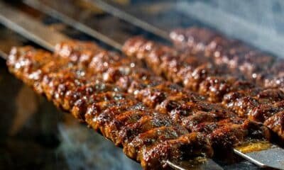 Several minced-meat kebab skewers grilling over charcoal